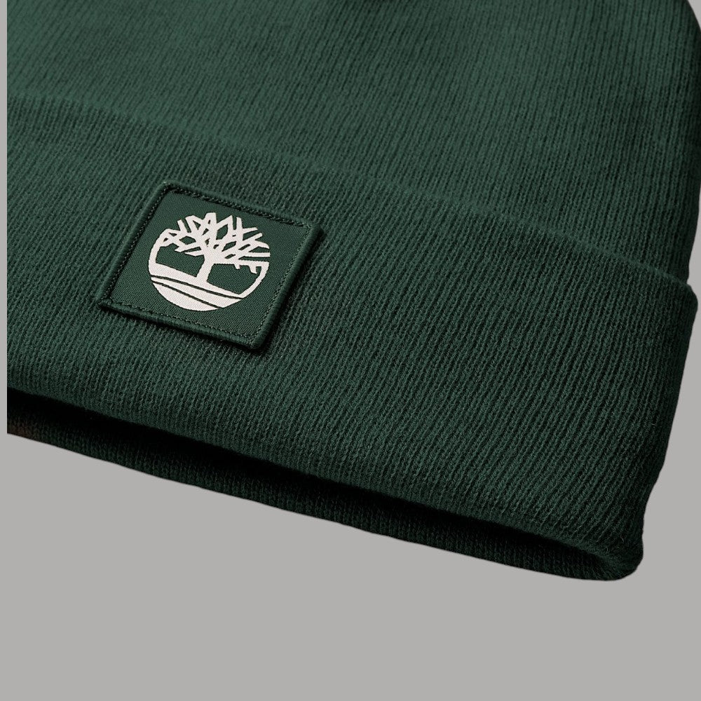 Dettaglio del risvolto a maglia verde e della patch con logo Timberland