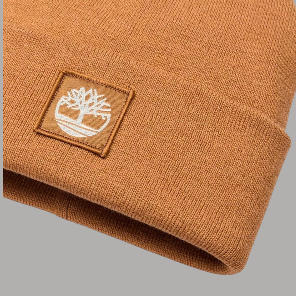Dettaglio del risvolto a maglia ocra e della patch con logo Timberland