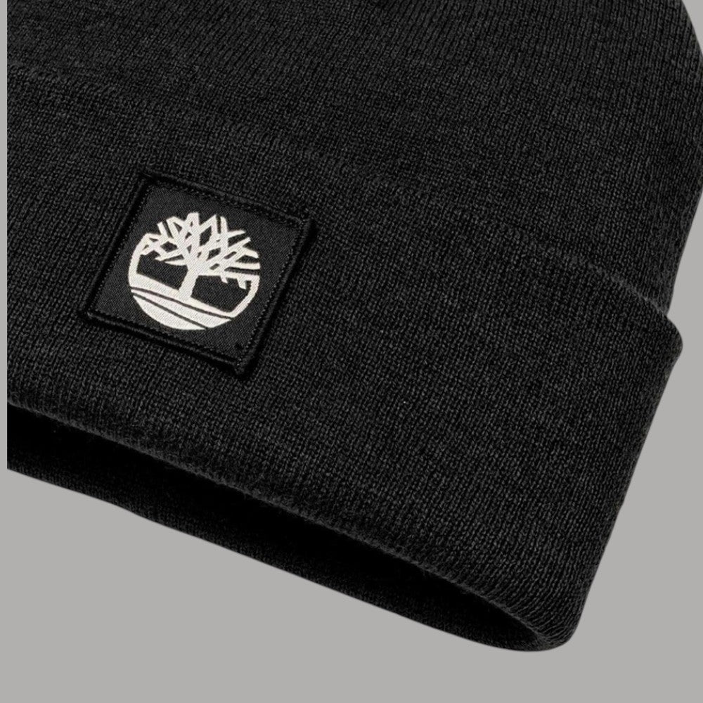 Dettaglio del risvolto a maglia nero e della patch con logo Timberland