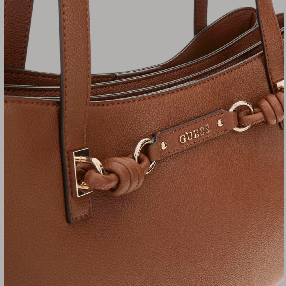 Dettaglio borsa tote cognac: zip, anelli metallici e nodo intrecciato