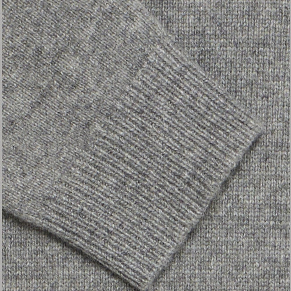 Maglione grigio melange: dettaglio lavorazione a maglia e bordo a costine.