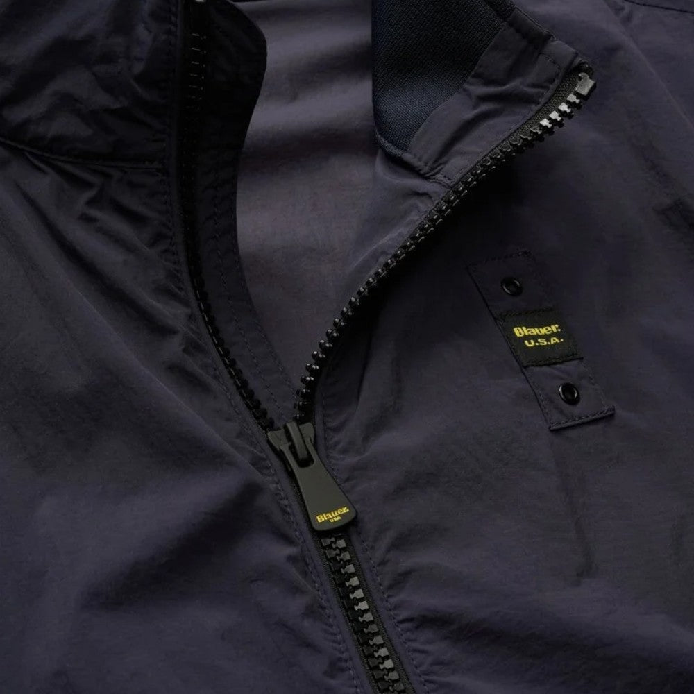 Bomber blu: zip con denti metallici ed etichetta sulla patta, dettaglio tessuto