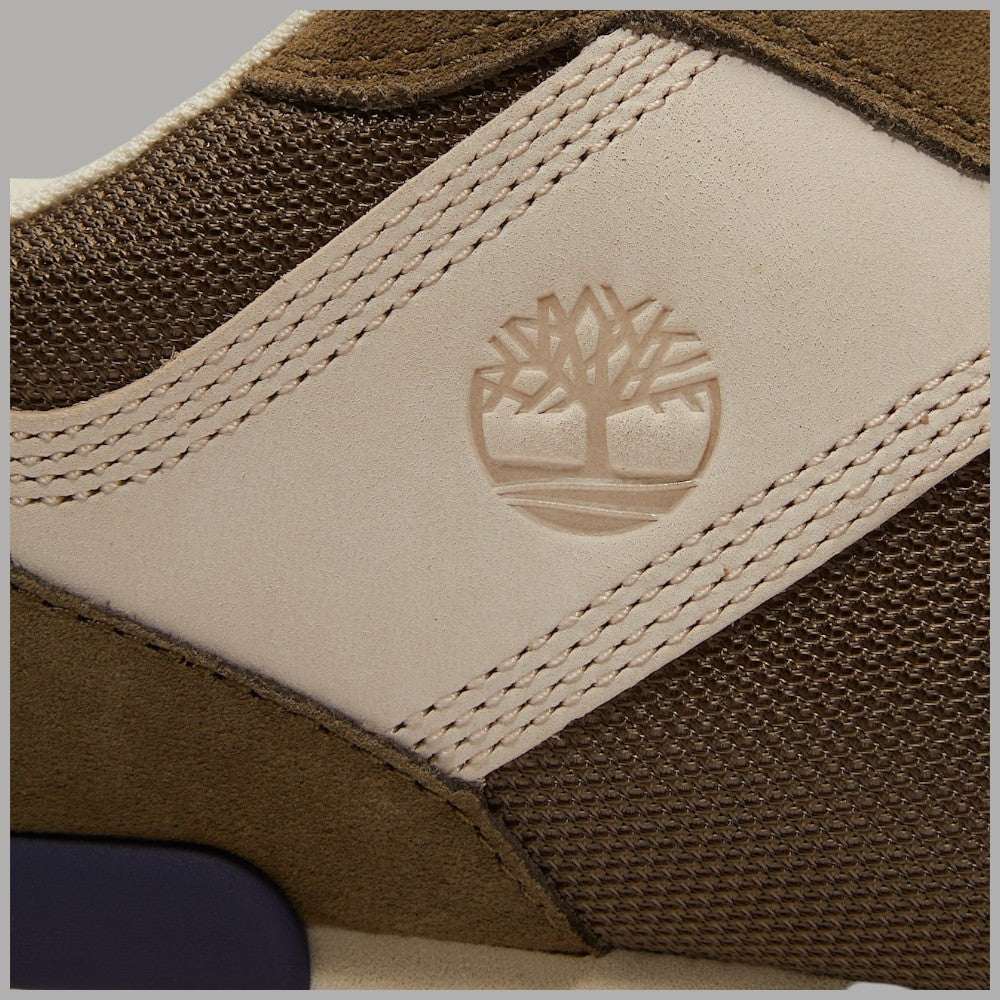 Dettaglio tomaia: pannello beige con logo albero in rilievo