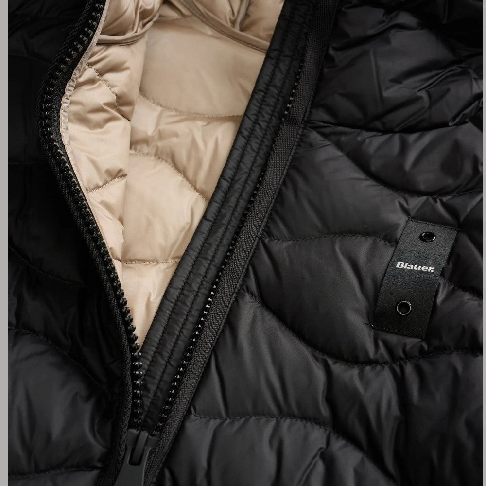 Dettaglio del piumino nero Blauer, con zip, imbottitura beige e logo