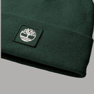 Dettaglio del risvolto a maglia verde e della patch con logo Timberland
