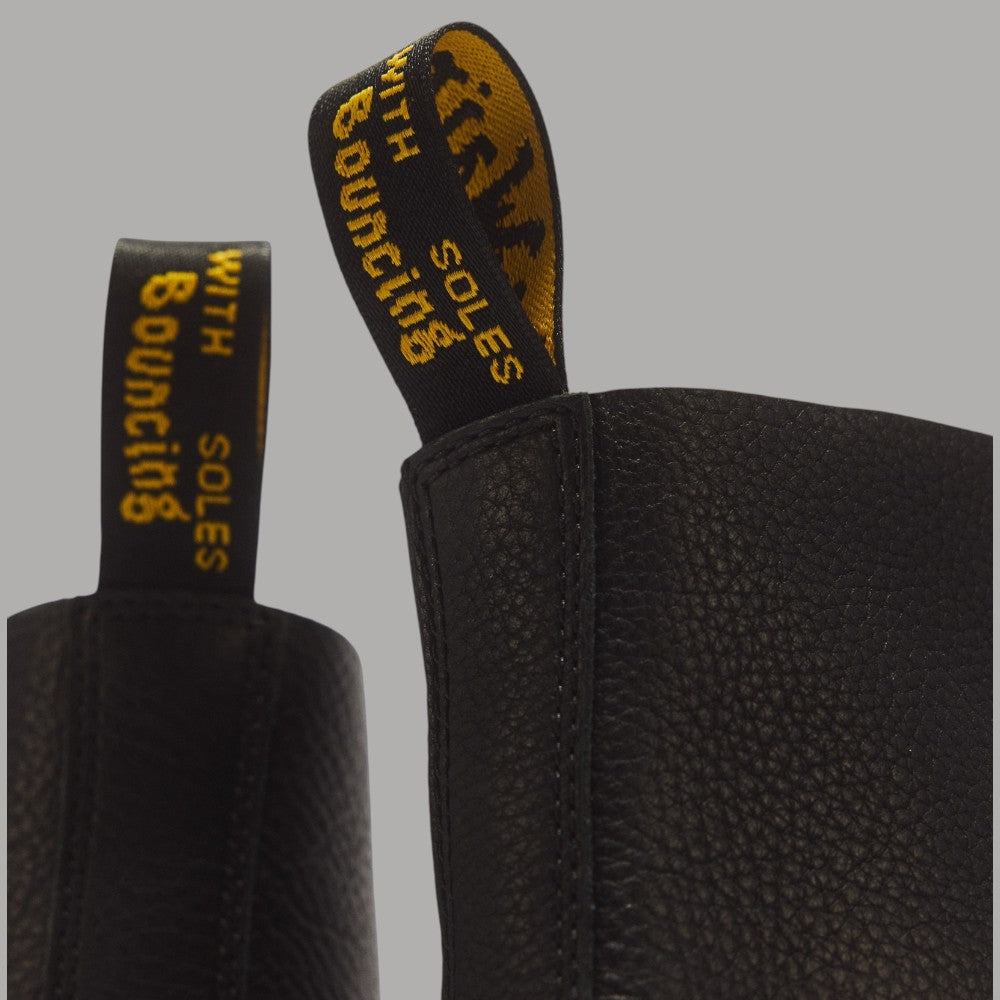 Dettaglio laterale dei stivali Dr Martens 1460 Pascal in pelle Ambassador nera con fodera con logo giallo e retro