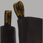 Dettaglio laterale dei stivali Dr Martens 1460 Pascal in pelle Ambassador nera con fodera con logo giallo e retro