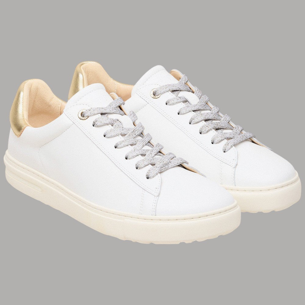 Coppia di sneaker bianche in pelle con lacci grigi e bordi oro sul tallone