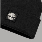 Dettaglio del risvolto a maglia nero e della patch con logo Timberland