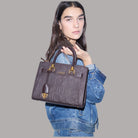 Borsa a mano piccola marrone scuro con logo a rilievo, charm dorato e manici doppi.