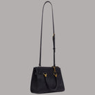 Borsa a mano piccola nera con tracolla lunga staccabile e charm dorato a catena.