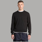 Maglione Timberland nero girocollo indossato, con piccolo logo sul petto