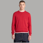 Maglione Timberland rosso a girocollo e maniche lunghe, indossato con jeans scuri