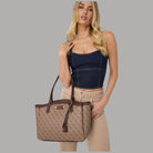 Borsa tote marrone Guess con logo e zip, tenuta in mano
