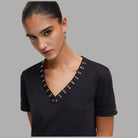 Abito corto nero in jersey con scollo a V e occhielli decorativi a fila