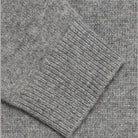 Maglione grigio melange: dettaglio lavorazione a maglia e bordo a costine.