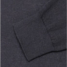 Maglione scuro in maglia: dettaglio cucitura e bordo a costine