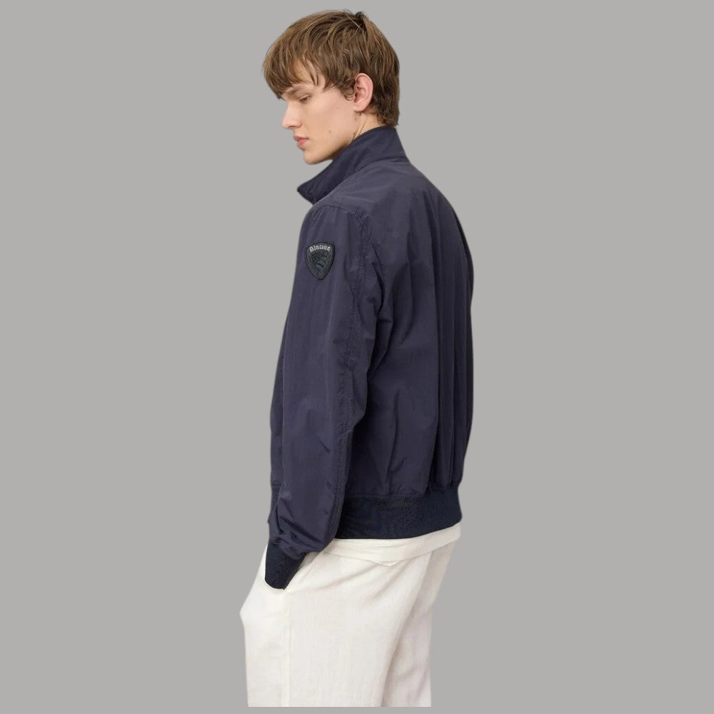 Bomber blu con zip e toppa sul braccio, profilo laterale e polsini elastici