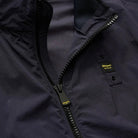 Bomber blu: zip con denti metallici ed etichetta sulla patta, dettaglio tessuto