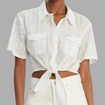 Camicia bianca in cotone corta, bottoni frontali e tasche con ricamo traforato.