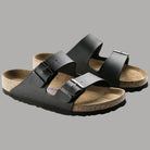 Ciabatte nere Birkenstock Arizona SFB con due cinturini e suola antiscivolo sagomata.