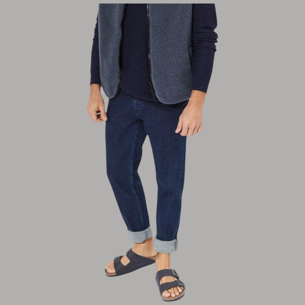 Ciabatte blu con due fibbie in metallo, indossate con jeans e calze grigie