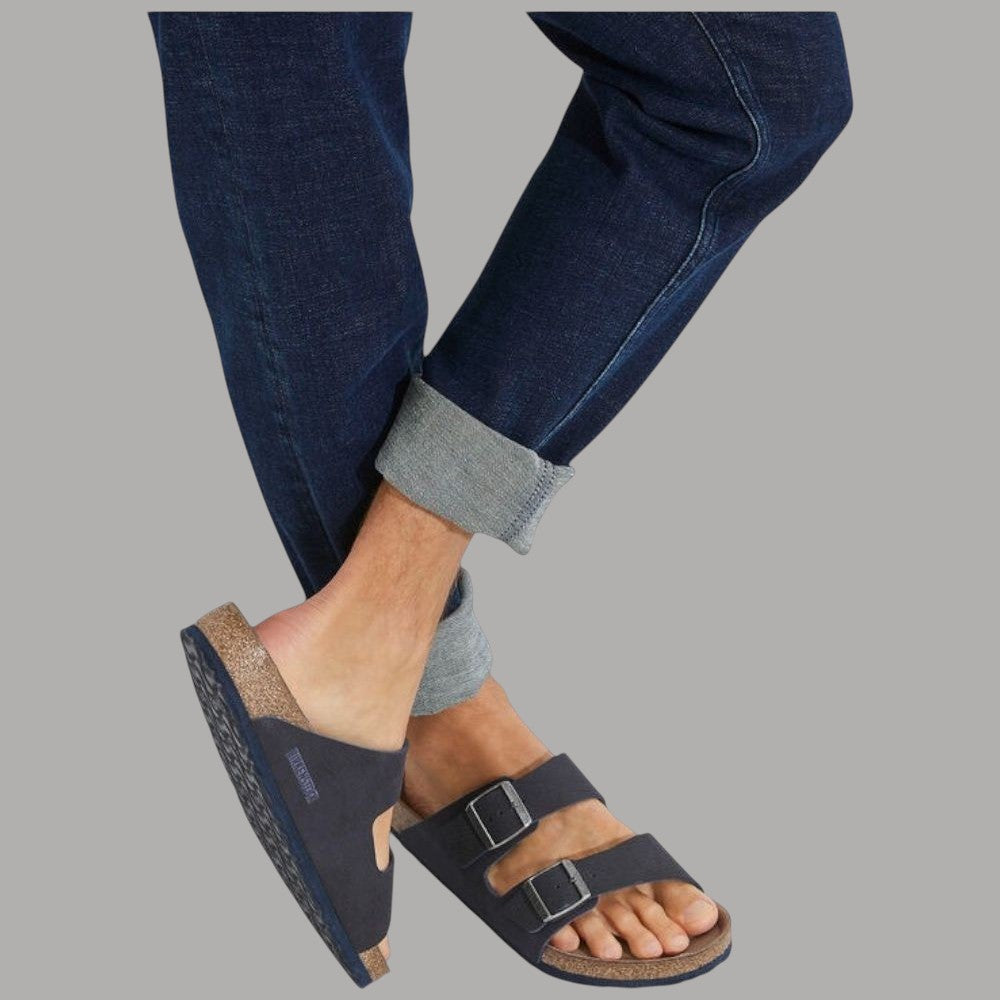 Ciabatte blu con due fibbie in metallo viste con jeans e calze grigie
