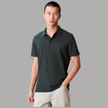 Polo Calvin Klein in cotone verde scuro, maniche corte, colletto e bottoni frontali.