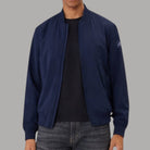 Giacca bomber blu con zip frontale, bordi a costine e logo laterale