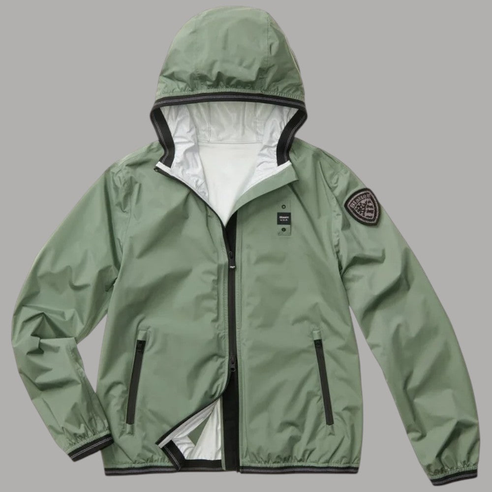 Giacca verde da donna con cappuccio fisso e patch sul braccio.