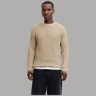 Maglione a coste beige chiaro con girocollo a costine e maniche lunghe.