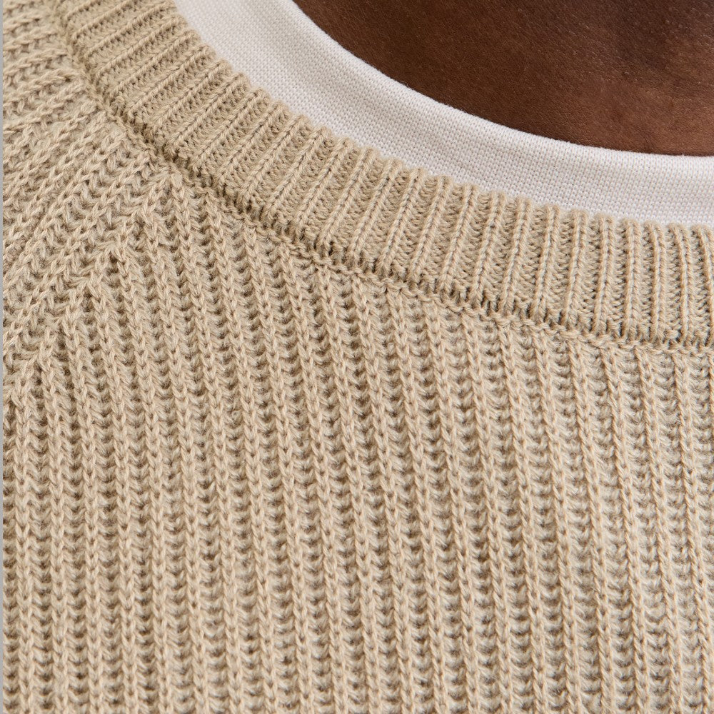 Maglione a coste beige chiaro: dettaglio del punto e della trama.