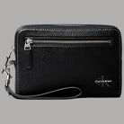 Pochette Calvin Klein nera con logo signature, cinturino da polso rimovibile, texture saffiano