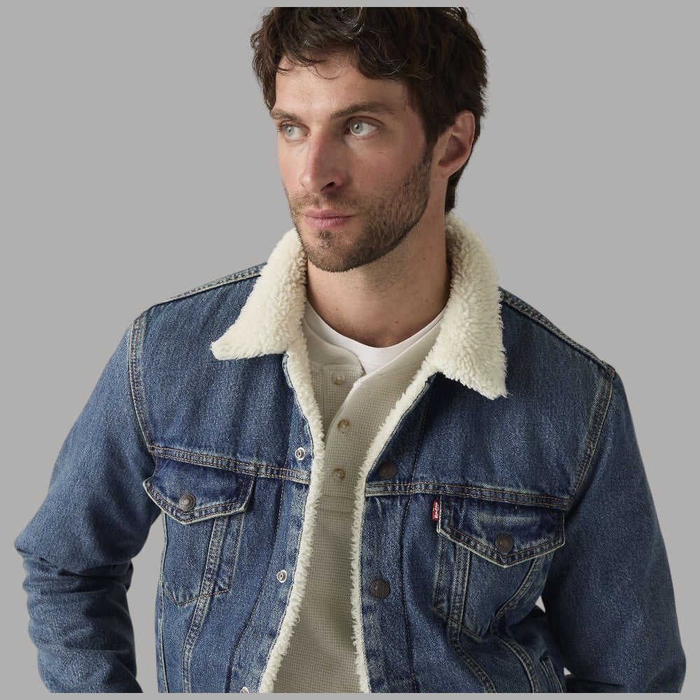 Giacca Levi's Trucker in denim blu con colletto sherpa crema e bottoni frontali in vista.