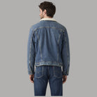 Giacca Levi's Trucker denim blu con retro in denim e bordo sherpa crema sul collo.