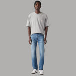 Jeans uomo in denim blu chiaro, taglio tapered, chiusura con bottone