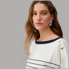Maglia a righe bianca e blu con scollo tondo e patch decorativa sulla spalla