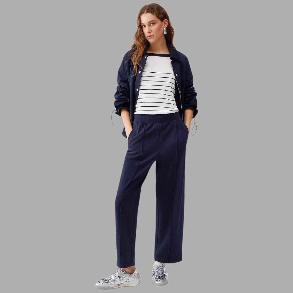 Maglia a righe bianca e blu con scollo tondo, indossata sotto giacca scura