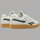 Scarpe Reebok bianche con tallone, inserti verdi e suola gum