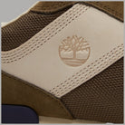 Dettaglio tomaia: pannello beige con logo albero in rilievo