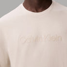 T-shirt beige in cotone con logo goffrato Calvin Klein in primo piano