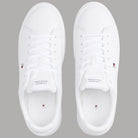 Sneakers bianche in pelle viste dall’alto con lacci e logo sulla linguetta
