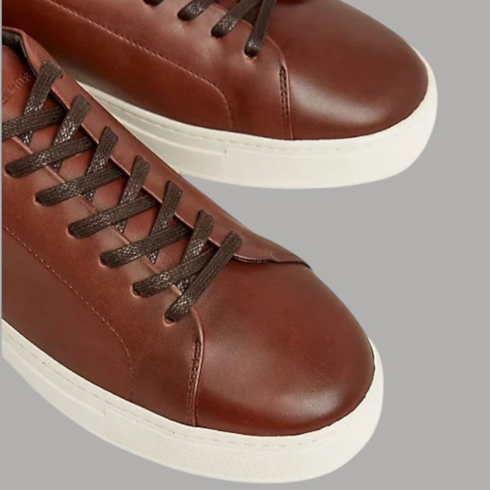 Sneakers in pelle marrone con lacci scuri e occhielli
