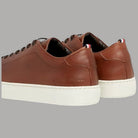 Sneakers in pelle marrone con linguetta imbottita e suola bianca