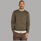 Maglione girocollo oliva con bordo a costine e logo sul petto.