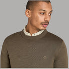 Maglione oliva girocollo con logo Timberland sul petto e costine al collo.