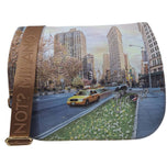 Borsa a tracolla beige con stampa città, tracolla marrone e chiusura a pattina.