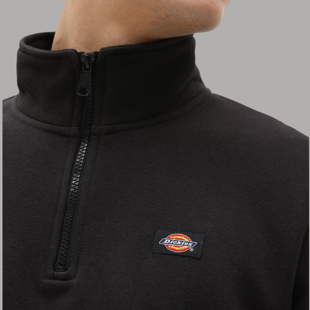Dettaglio felpa mezza zip: colletto alto e logo Dickies su tessuto scuro