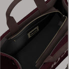 Dettaglio borsa tote bordeaux: zip dorata, fodera scura e tasca con logo Liu Jo.