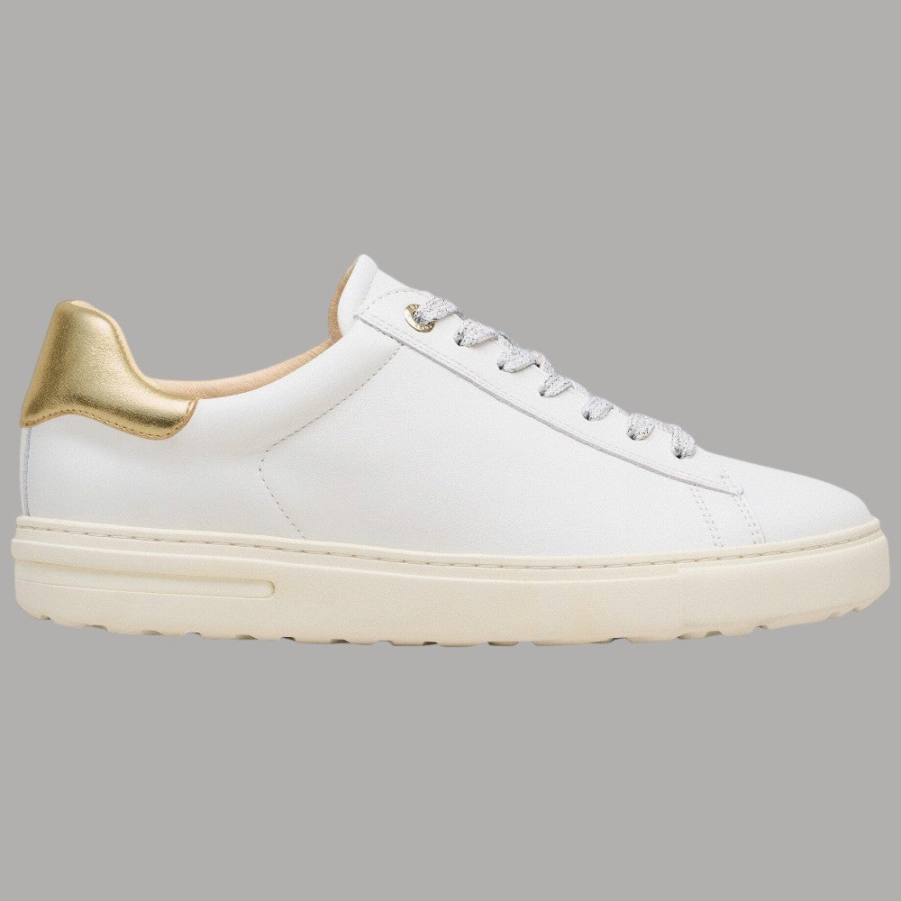 Sneaker bianca in pelle con bordo oro al tallone e lacci chiari, suola spessa